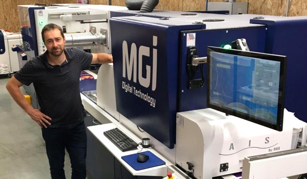 Photo of Pyramidor's manager in front of the JETvarnish 3D Web digital press from MGI Digital Technology that he recommends