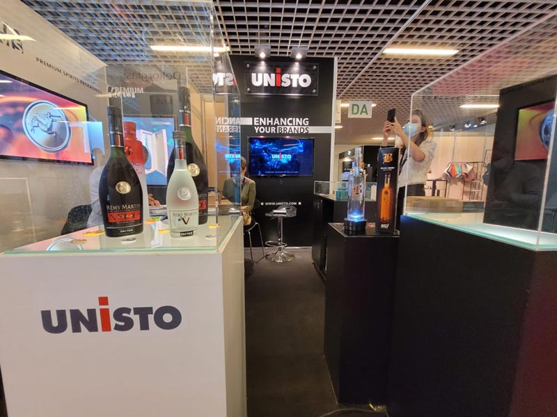 Photo du stand Unisto à Label Expo avec des échantillons embellis sur presse numérique de MGI Digital Technology
