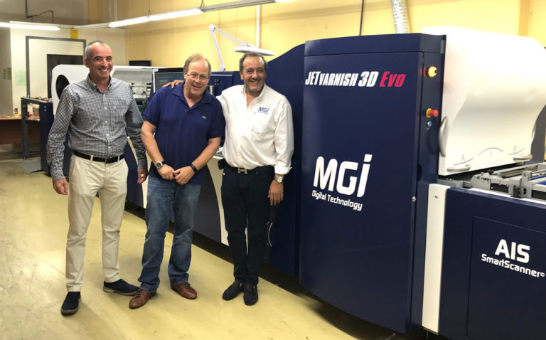 Photo de la JETvarnish 3D Evo de MGI Digital Technology, avec les dirigeants de l'imprimerie Heret et Victor Abergel, à réception de leur équipement